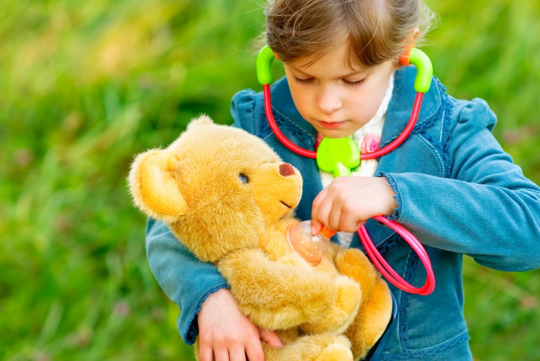Girl listens stethoscope to plush bear